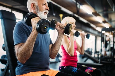 Fit couple doing exercises in the gym to combat belly fat and weight gain