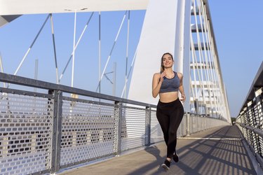 Young sports woman jogging on the bridge