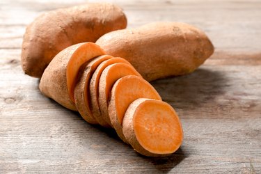 Sliced sweet potatoes on wooden table
