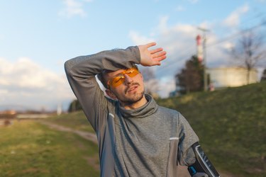 Guy in sauna suit wiping brow after running outside to show sauna suit before and after