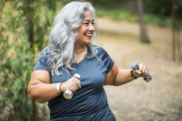 older adult weightlifting with dumbbells outside