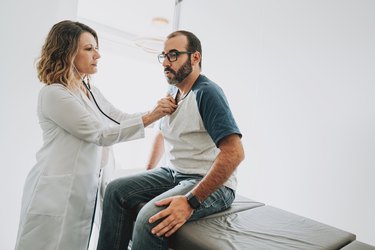Doctor listening to a patient's heartbeat at the doctor's office