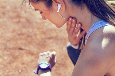Young woman measuring heart rate after running